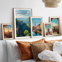 Framed travel posters of Blue Mountains, Paris, Copenhagen, Tokyo, and Barcelona above bed
