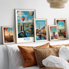 Bristol England Print – Hot Air Balloons Over Historic City Wall Art displayed among framed travel posters on a couch.
