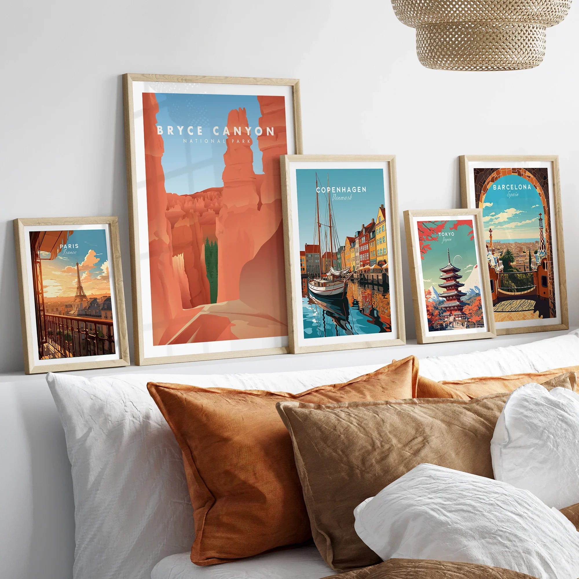 Framed travel art prints of Bryce Canyon, Paris, Copenhagen, Tokyo, Barcelona above a bed.