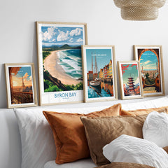 Byron Bay Wall Art Print Australia displayed among other coastal city prints on a stylish couch.