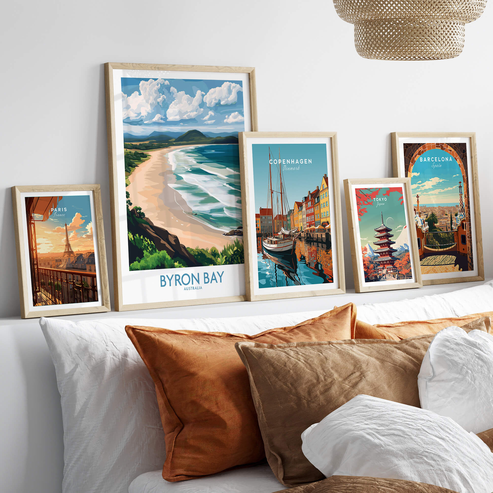 Byron Bay Wall Art Print Australia displayed among other coastal city prints on a stylish couch.