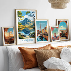 Set of five framed travel art prints above bed, featuring Paris, Wales, Copenhagen, Tokyo, and Barcelona.