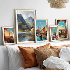 Framed travel posters of Paris, Wales, Copenhagen, Tokyo, and Barcelona above a bed