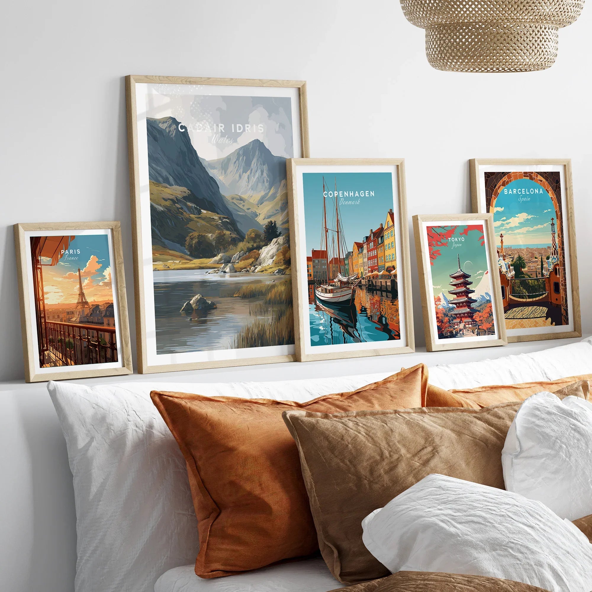 Framed travel posters of Paris, Wales, Copenhagen, Tokyo, and Barcelona above a bed