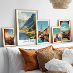 Framed travel posters of Paris, Cadair Idris, Copenhagen, Tokyo, and Barcelona above a bed.
