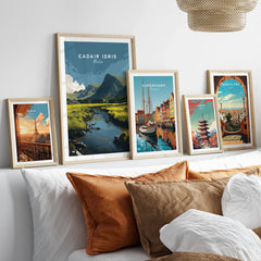 Set of five framed travel art prints above a bed, showcasing famous city and nature scenes.
