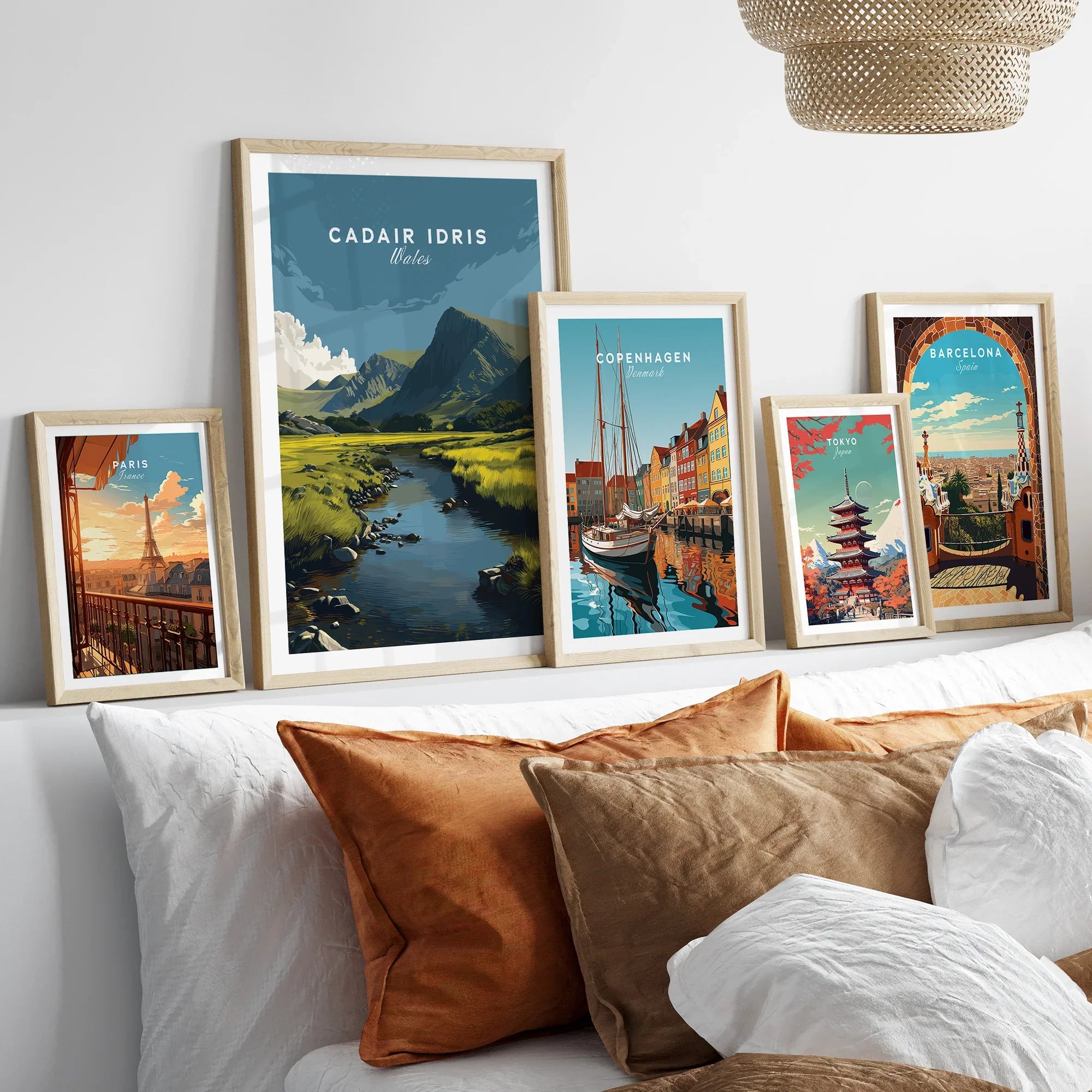 Set of five framed travel art prints above a bed, showcasing famous city and nature scenes.