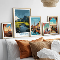 Set of five framed travel art prints above bed, featuring Paris, Cadair Idris, Copenhagen, Tokyo, Barcelona.