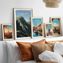Framed travel posters of Cadair Idris, Copenhagen, Paris, Tokyo, and Barcelona above bed