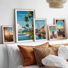 Captiva Island Travel Poster – Florida Beach Houses and Palm Trees Art displayed among various travel posters on a cozy couch.