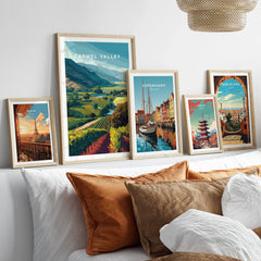 Set of five framed travel art prints above bed, featuring Paris, Carmel Valley, Copenhagen, Tokyo, Barcelona.