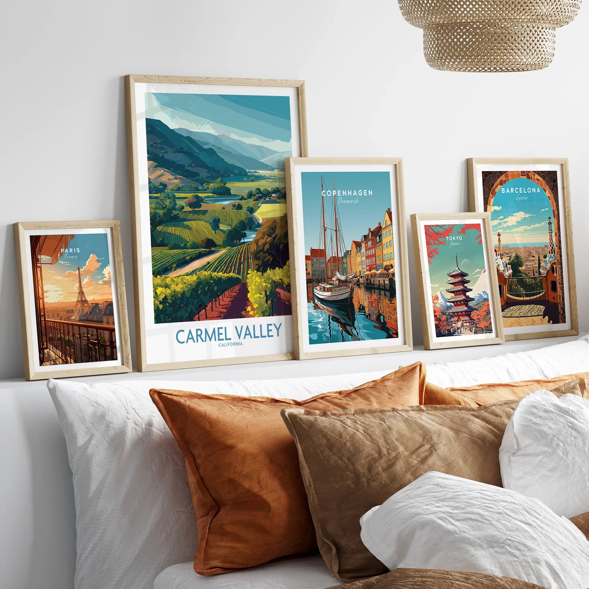 Framed travel posters of Carmel Valley, Paris, Copenhagen, Tokyo, and Barcelona above a bed