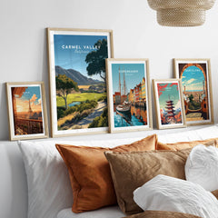 Framed travel posters of Carmel Valley, Paris, Copenhagen, Tokyo, and Barcelona above bed
