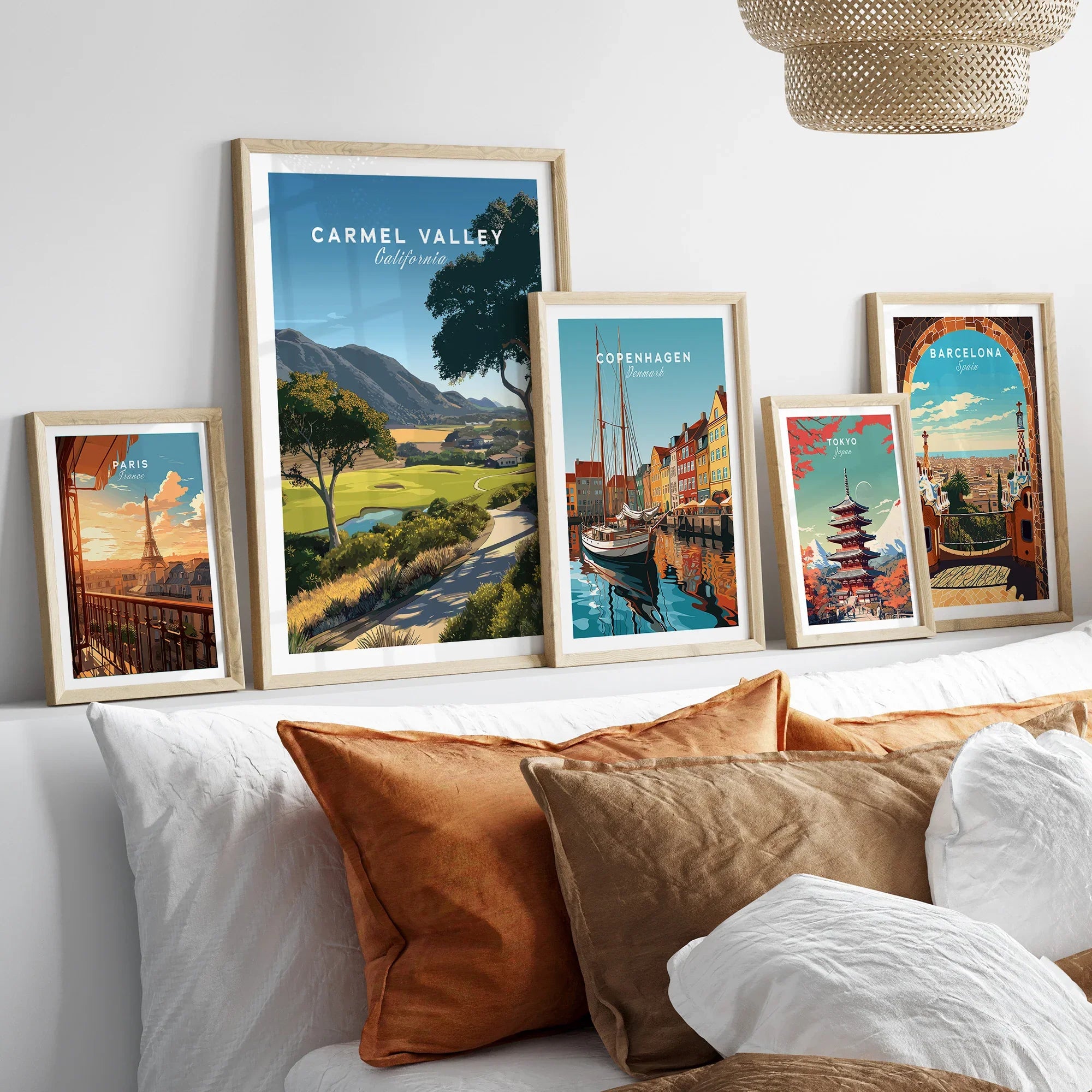 Framed travel posters of Carmel Valley, Paris, Copenhagen, Tokyo, and Barcelona above bed