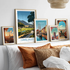 Framed travel art prints of Paris, Carmel Valley, Copenhagen, Tokyo, and Barcelona above a bed