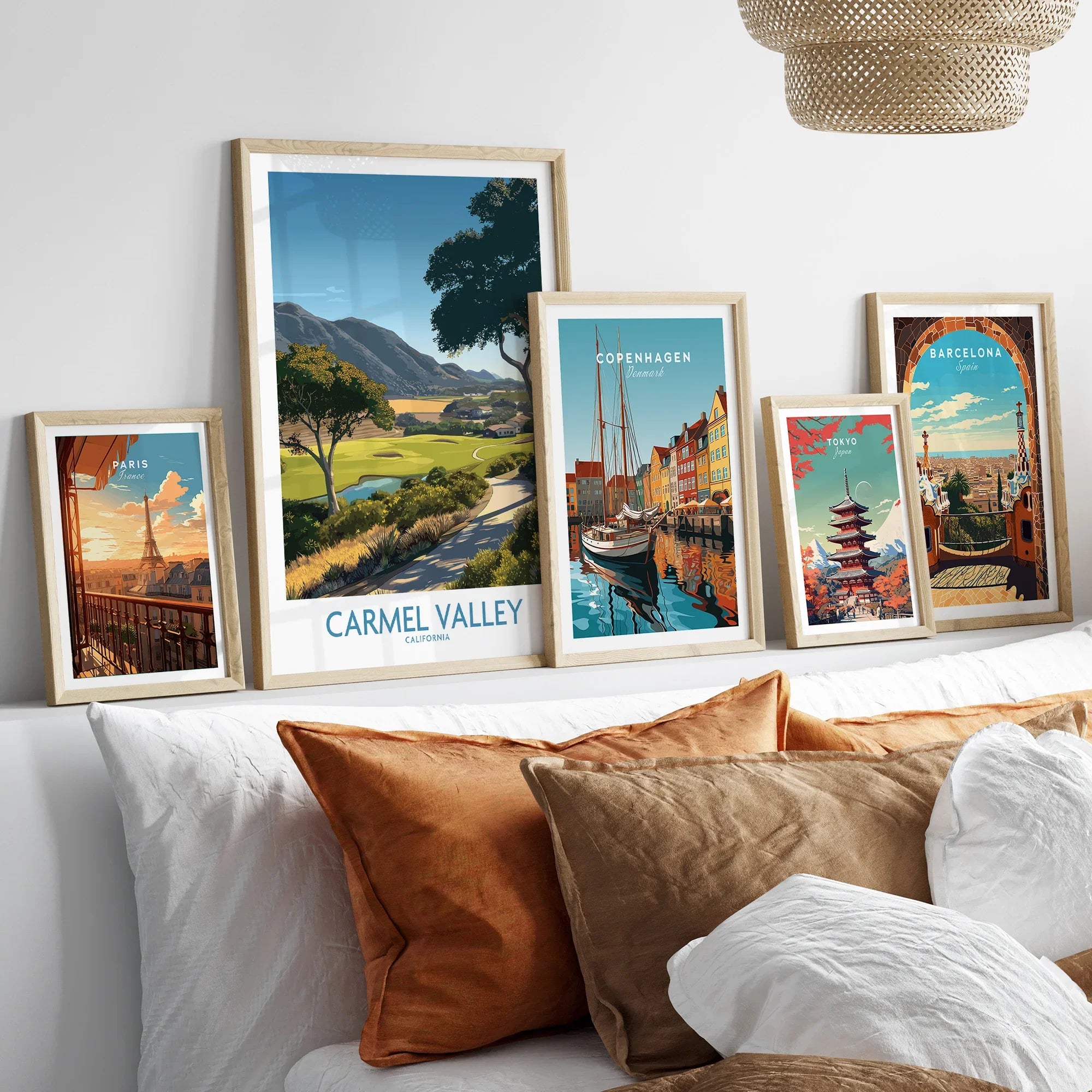 Framed travel art prints of Paris, Carmel Valley, Copenhagen, Tokyo, and Barcelona above a bed