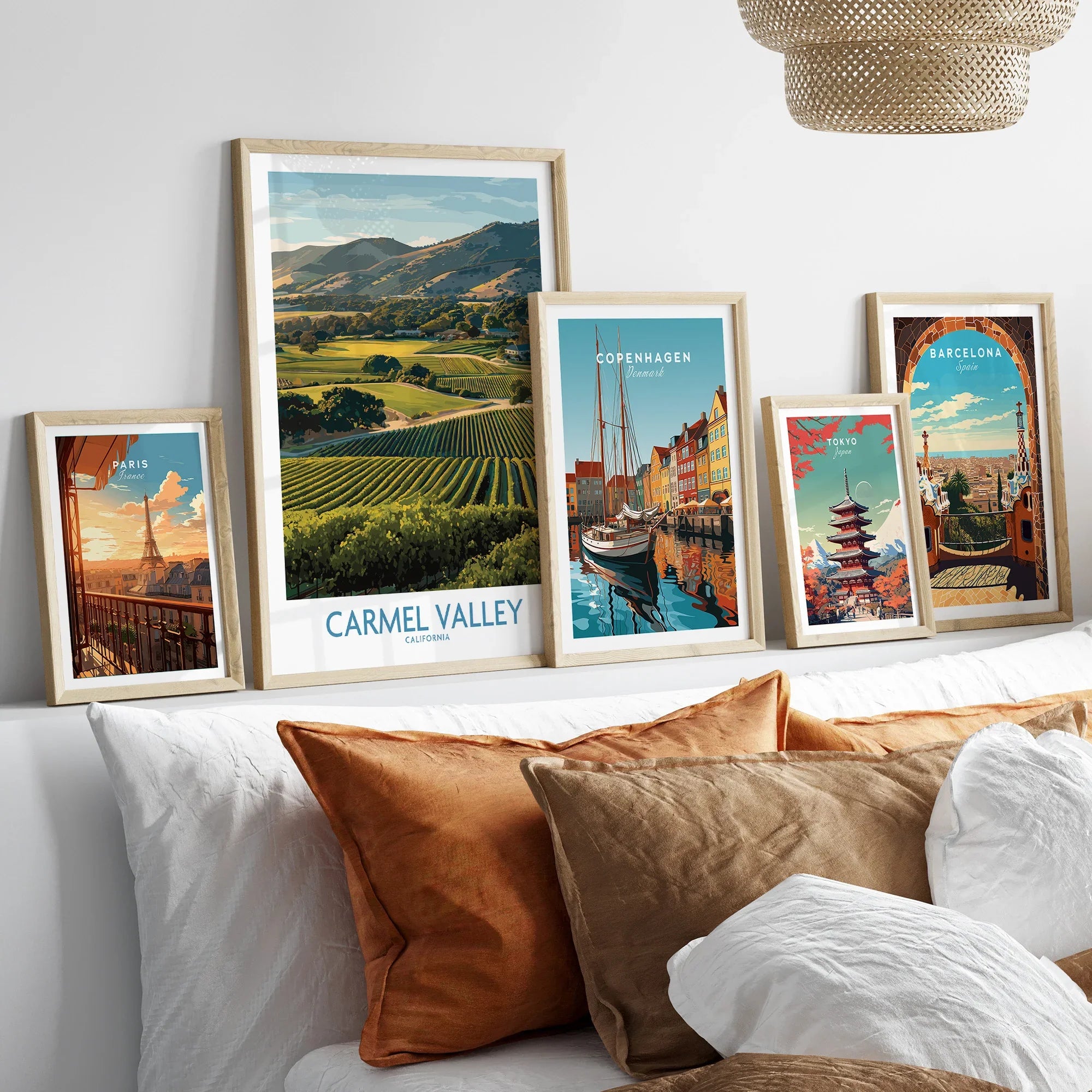 Set of five framed travel art prints above bed, featuring landscapes and city skylines.
