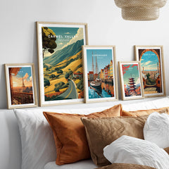 Framed travel art prints of Carmel Valley, Paris, Copenhagen, Tokyo, and Barcelona above bed