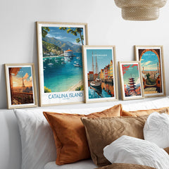 Framed travel posters above a bed featuring Catalina Island, Paris, Copenhagen, Tokyo, and Barcelona.