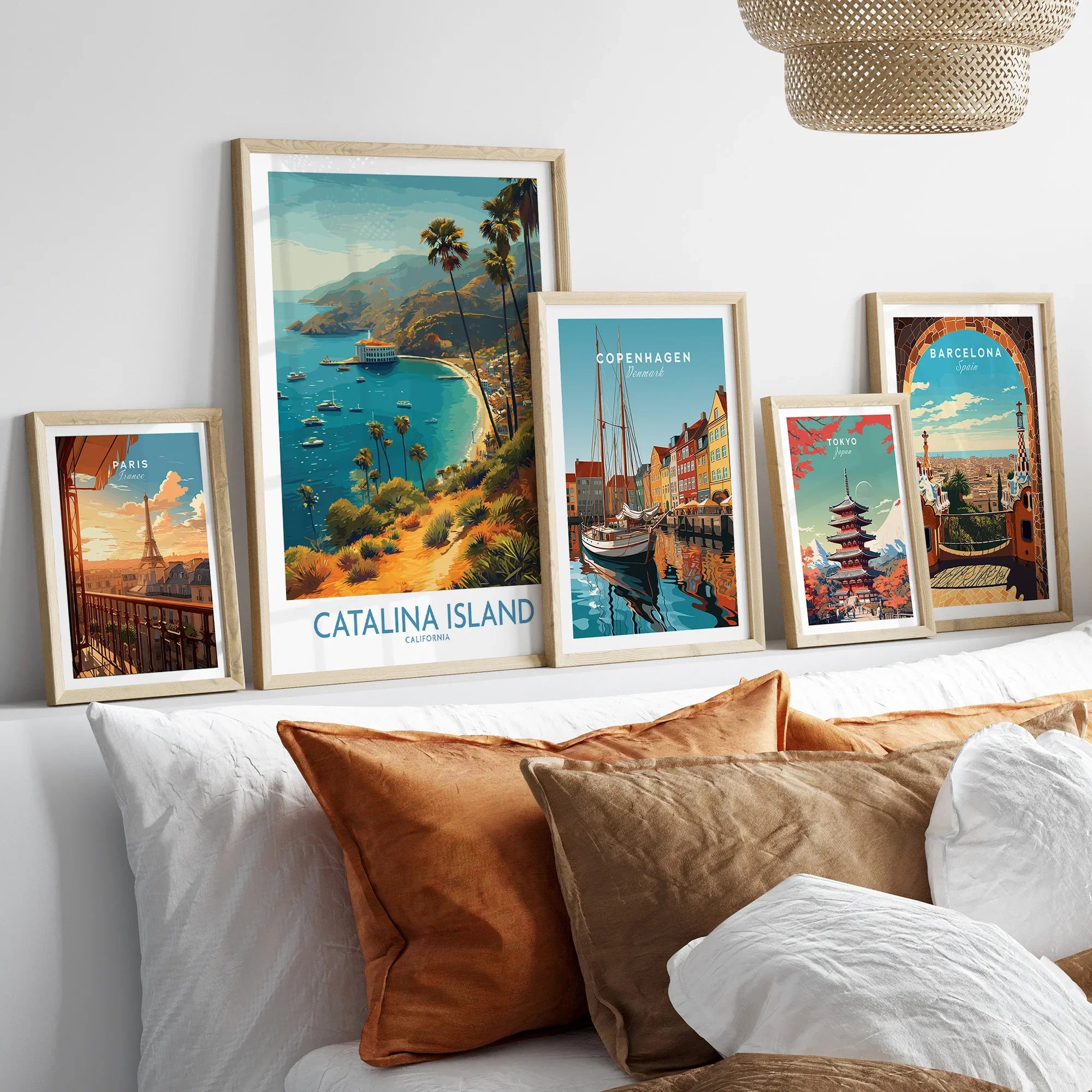 Framed travel posters of Catalina Island, Paris, Copenhagen, Tokyo, and Barcelona above bed