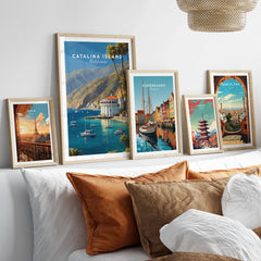 Framed travel poster art prints of Catalina Island, Paris, Copenhagen, Tokyo, and Barcelona above bed