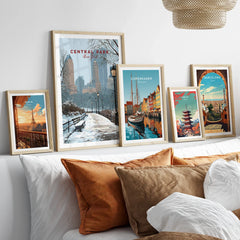 Framed travel art prints of Central Park, Paris, Copenhagen, Tokyo, and Barcelona above a bed