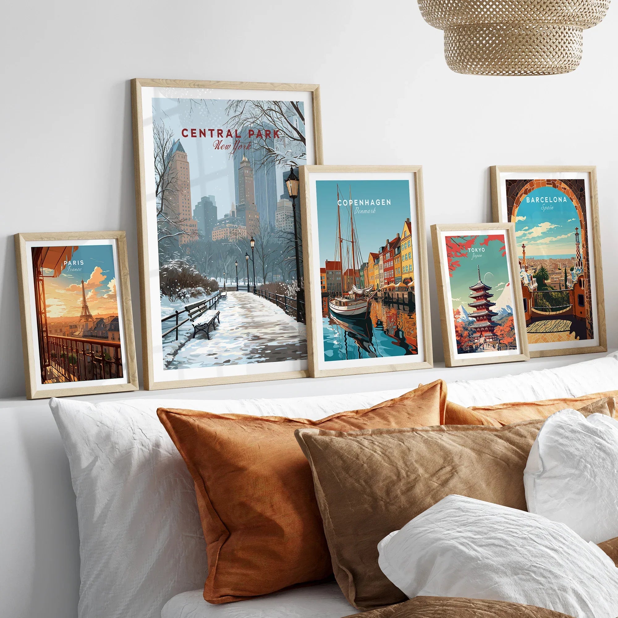 Framed travel art prints of Central Park, Paris, Copenhagen, Tokyo, and Barcelona above a bed