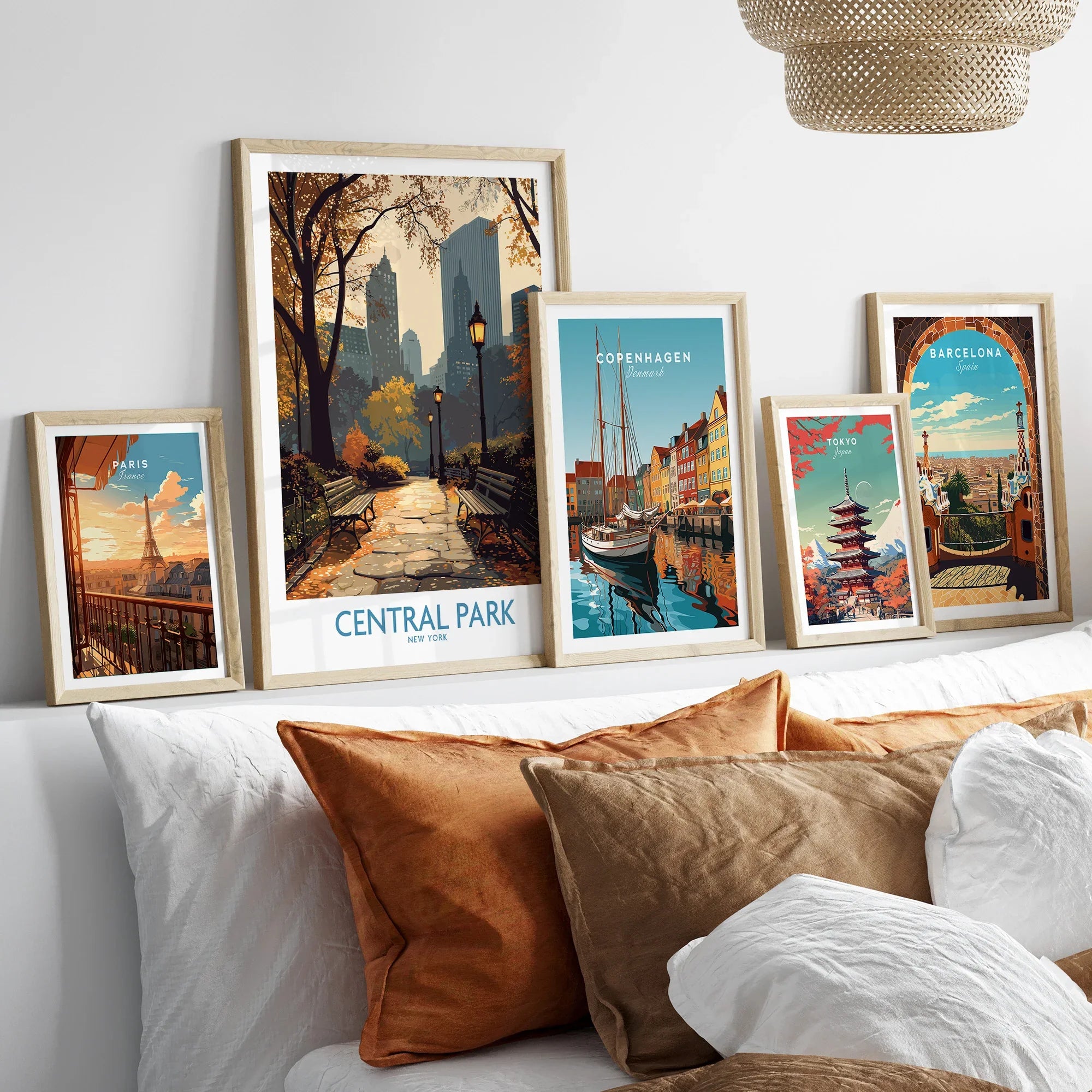 Framed travel art prints of Central Park, Paris, Copenhagen, Tokyo, and Barcelona above bed
