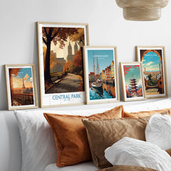 Set of five framed travel posters above bed, featuring Central Park, Paris, Copenhagen, Tokyo, Barcelona.