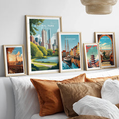 Set of five framed travel posters above bed, featuring Central Park, Paris, Copenhagen, Tokyo, Barcelona.