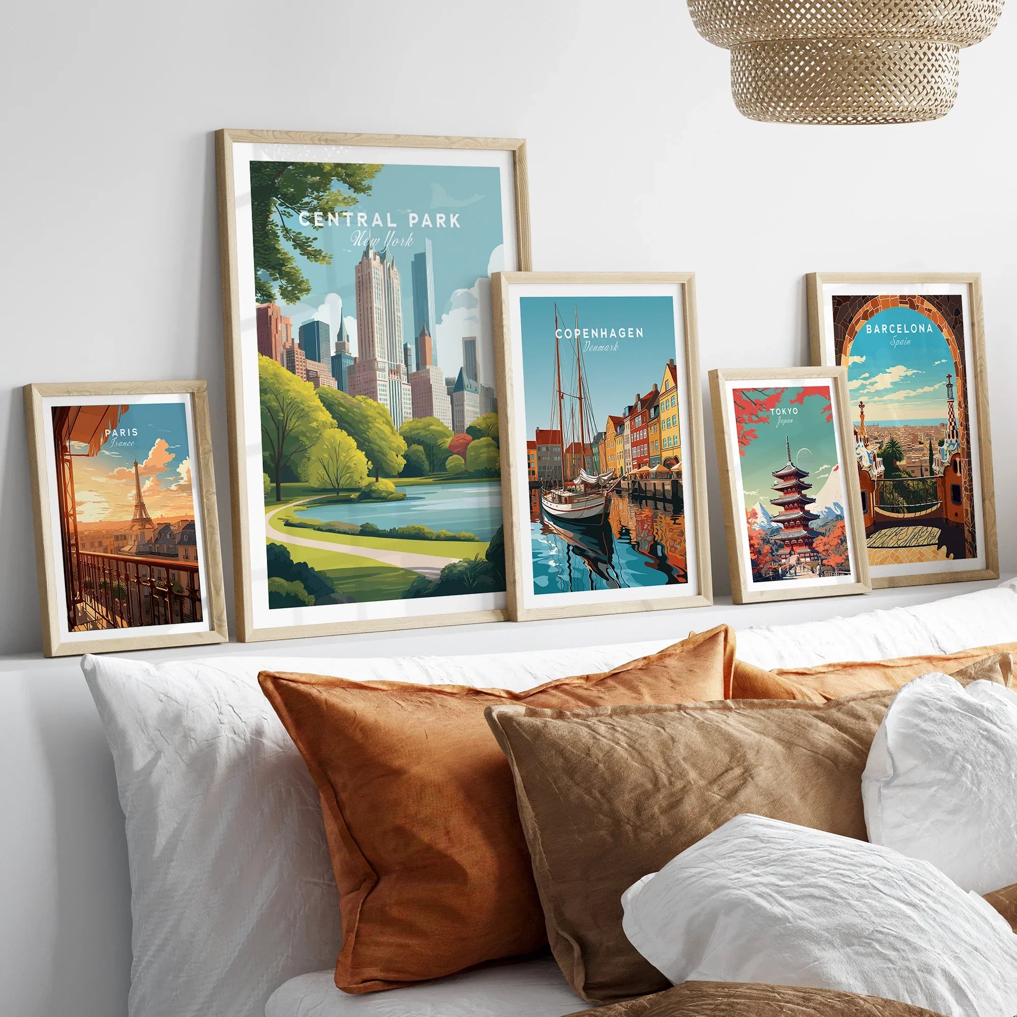 Set of five framed travel posters above bed, featuring Central Park, Paris, Copenhagen, Tokyo, Barcelona.