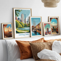 Set of framed travel posters above bed, featuring Central Park, Paris, Copenhagen, Tokyo, Barcelona.
