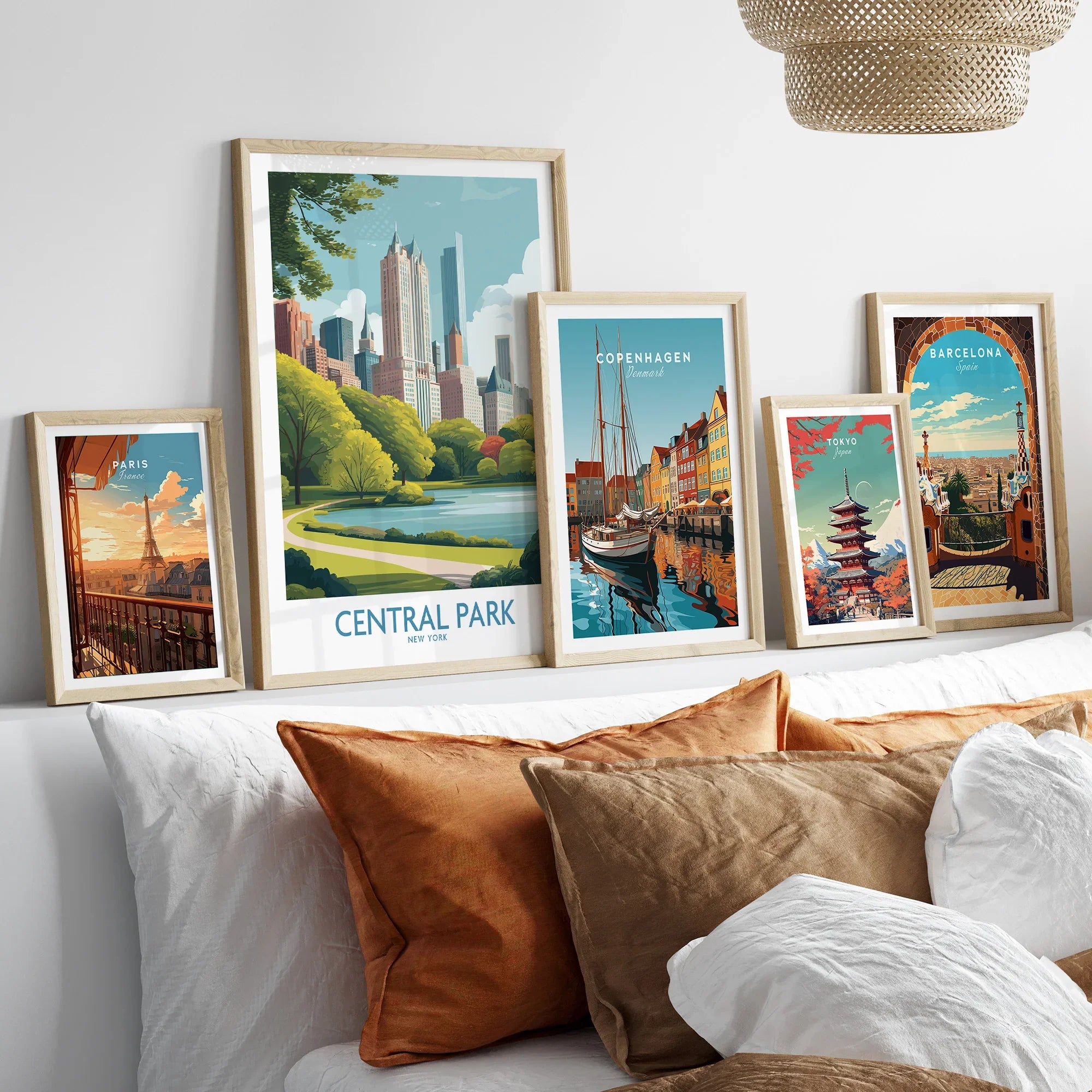 Set of framed travel posters above bed, featuring Central Park, Paris, Copenhagen, Tokyo, Barcelona.