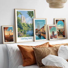 Travel posters set with Paris, Central Park, Copenhagen, Tokyo, and Barcelona in wood frames above bed