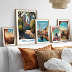 Framed travel posters for Paris, Central Park, Copenhagen, Tokyo, and Barcelona above a bed.