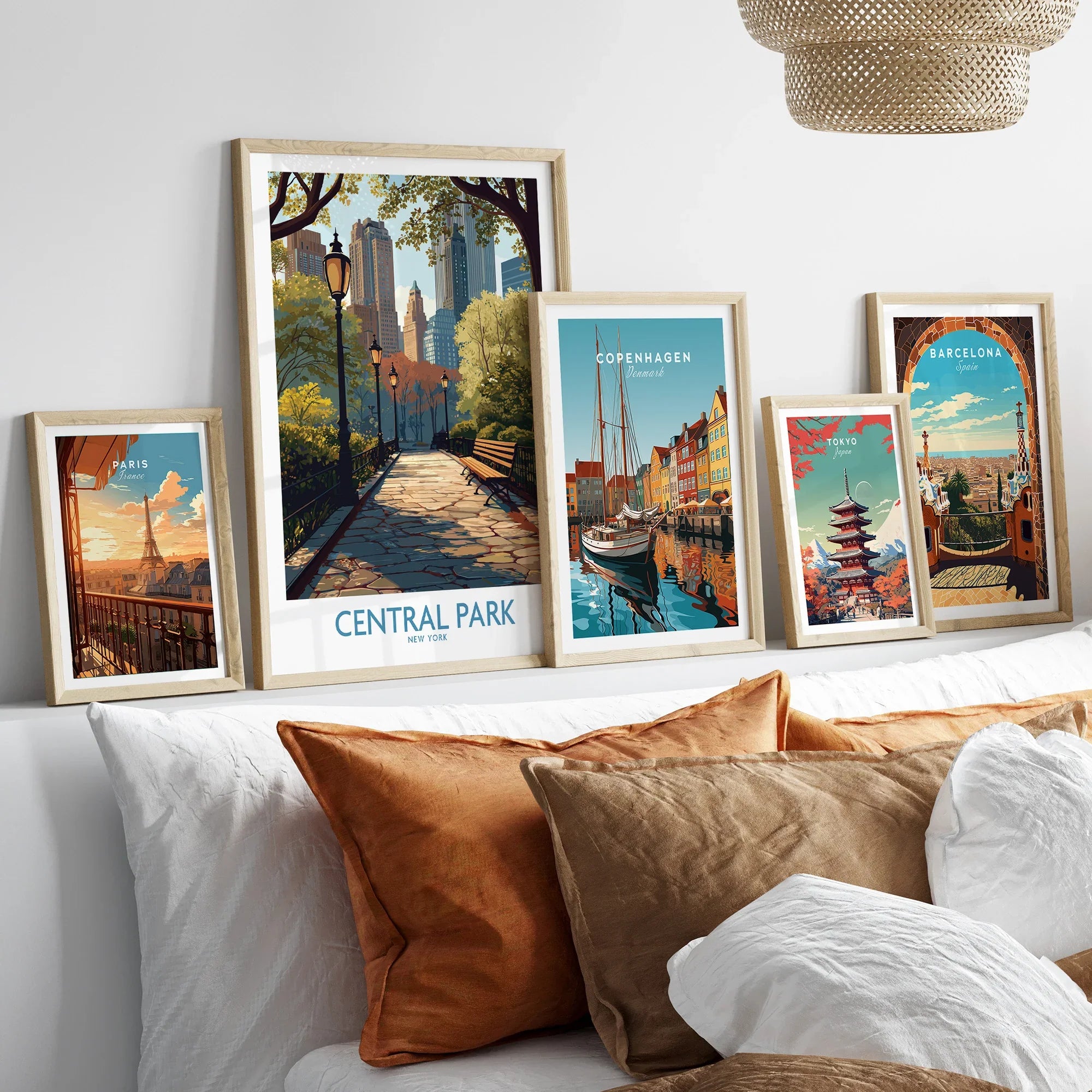Framed travel posters for Paris, Central Park, Copenhagen, Tokyo, and Barcelona above a bed.