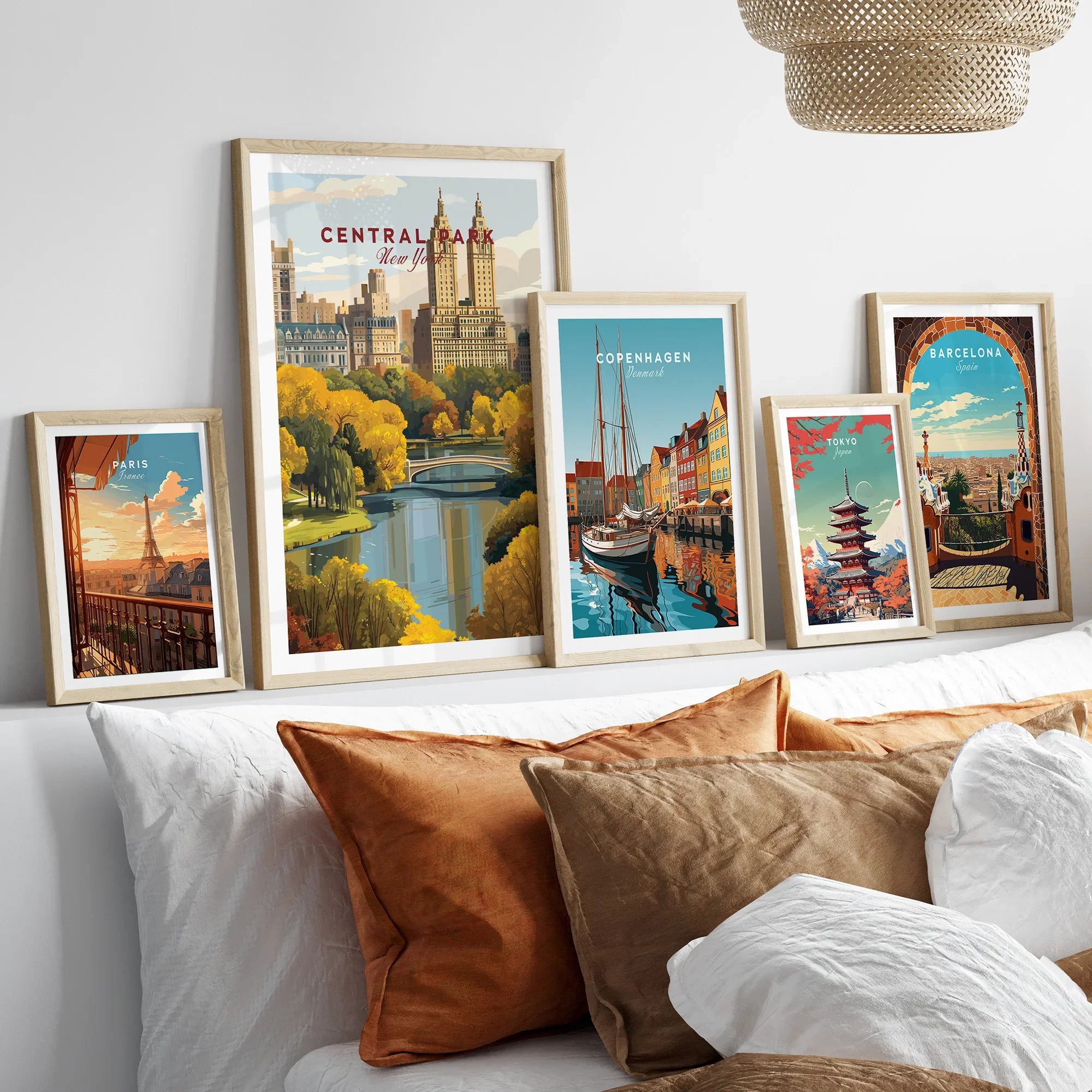 Set of five framed travel posters above bed, featuring Paris, New York, Copenhagen, Tokyo, Barcelona.