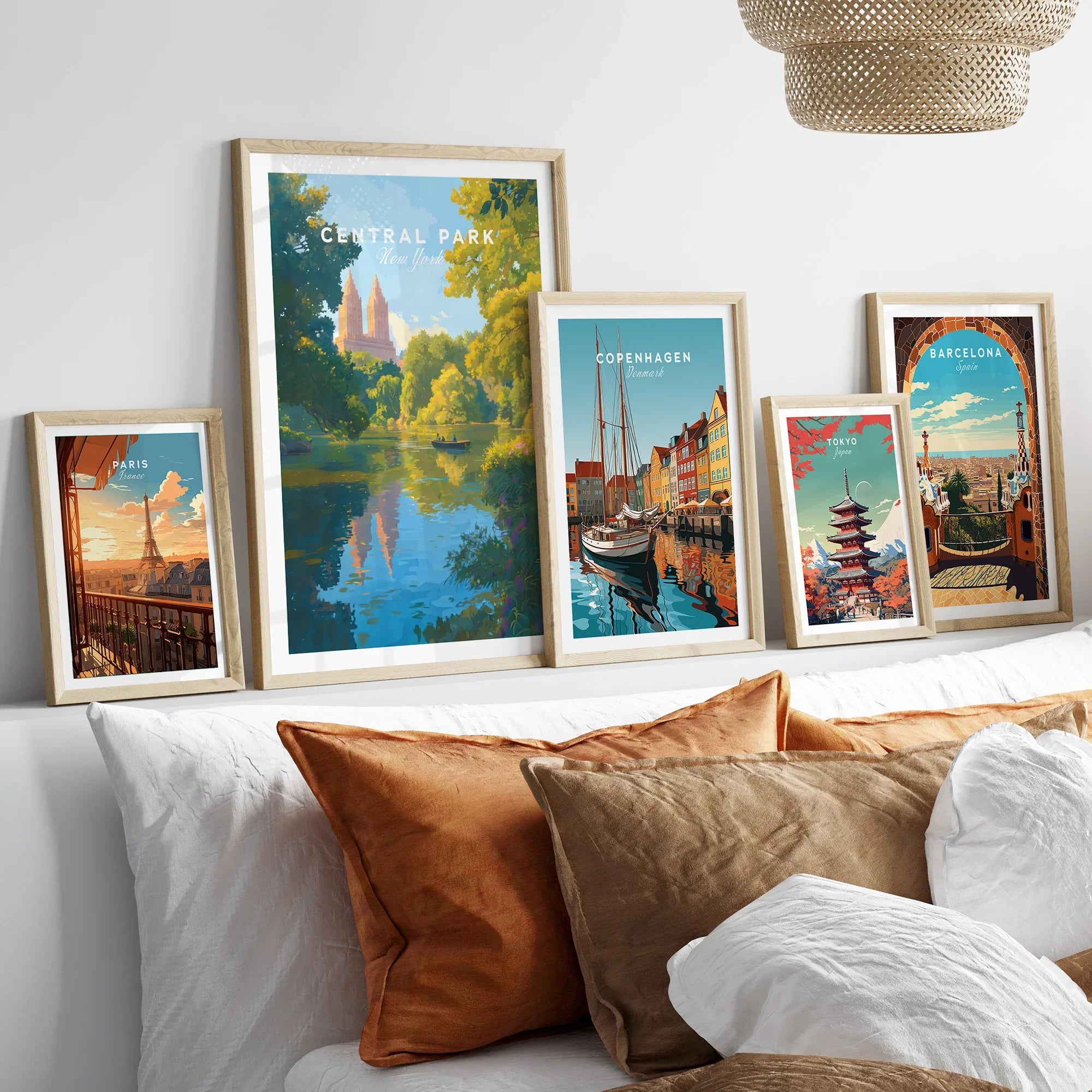 Framed travel posters of Central Park, Paris, Copenhagen, Tokyo, and Barcelona above a bed