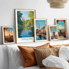 Set of five framed travel posters above bed, featuring city skylines and landmarks in natural wood frames.