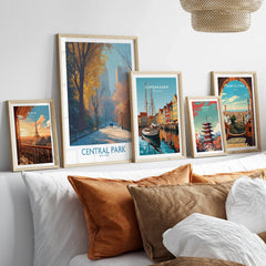 Framed travel posters of Central Park, Paris, Copenhagen, Tokyo, and Barcelona above a bed