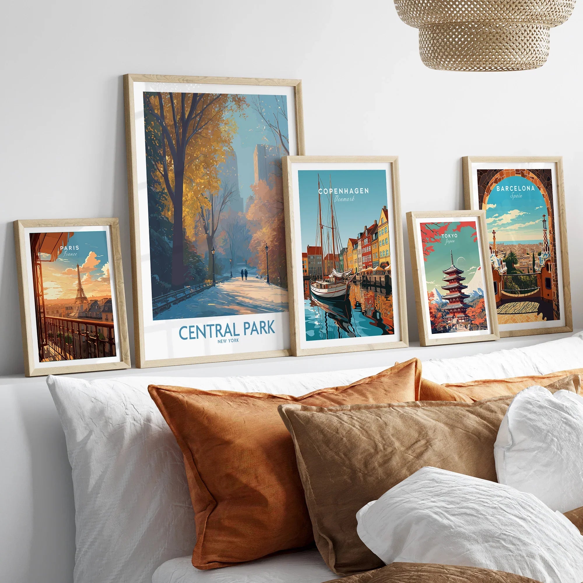 Framed travel posters of Central Park, Paris, Copenhagen, Tokyo, and Barcelona above a bed