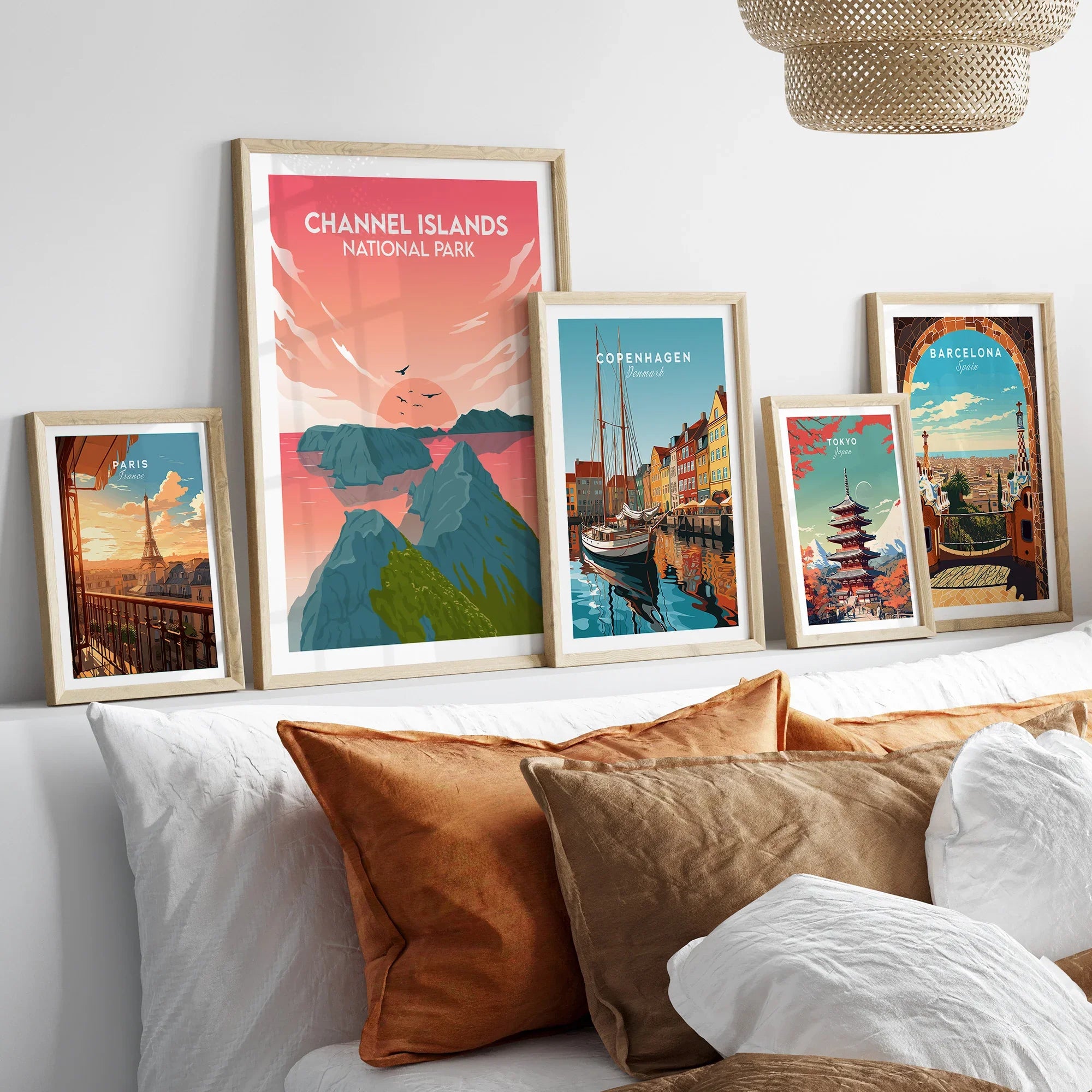 Framed travel art prints of Channel Islands, Paris, Copenhagen, Tokyo, and Barcelona above bed