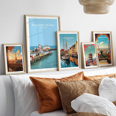 Clacton-on-Sea Travel Poster – Historic Pier Art Print displayed among other travel posters on a stylish bed.