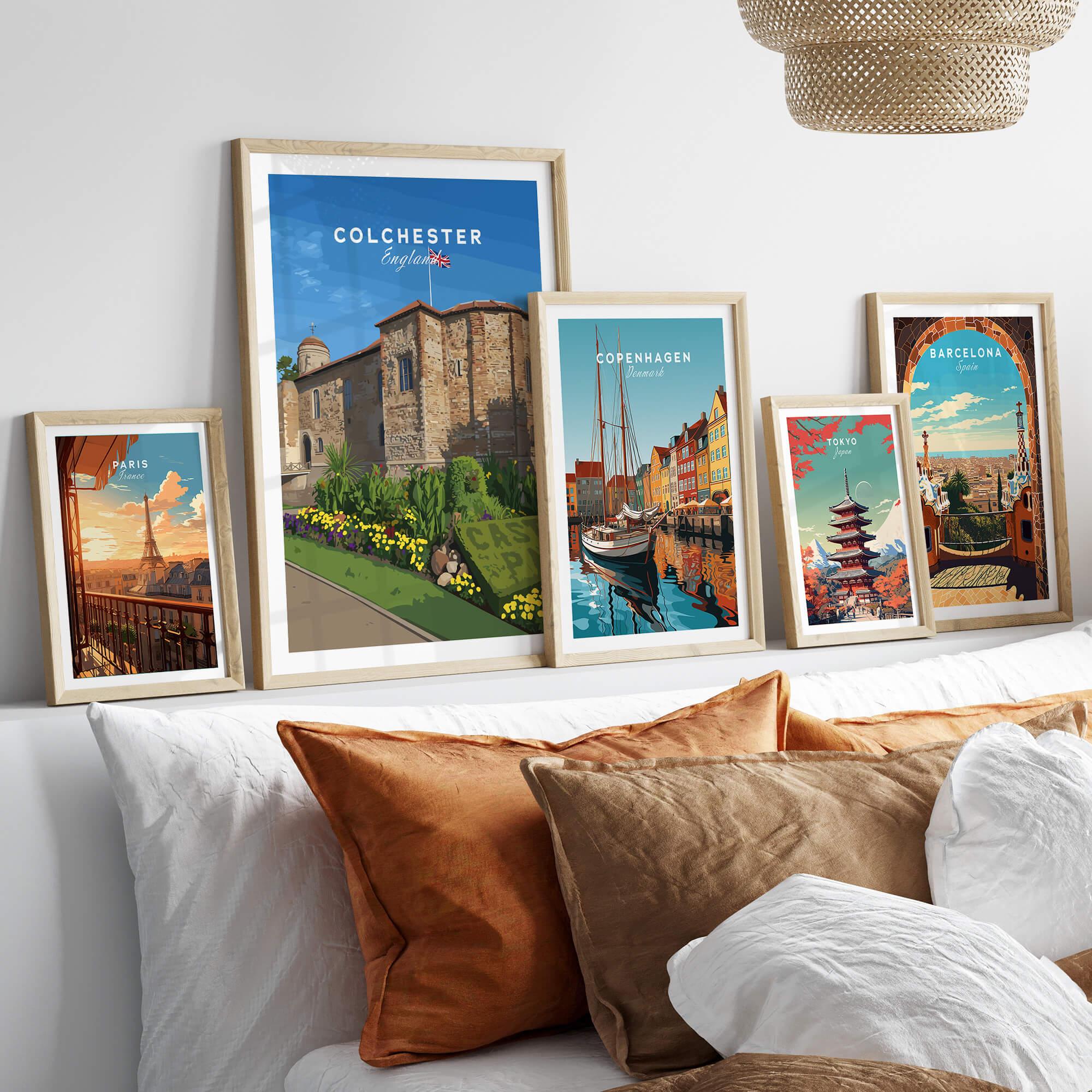 Set of five framed travel posters of Paris, Colchester, Copenhagen, Tokyo, and Barcelona above bed
