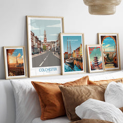 Set of five framed travel posters above bed, featuring Paris, Colchester, Copenhagen, Tokyo, Barcelona skyline art prints in natural wood frames.