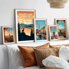Framed travel posters for Crater Lake, Paris, Copenhagen, Tokyo, and Barcelona above a bed