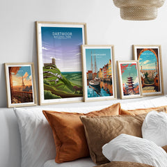 Travel poster wall art set in natural wood frames above bed, featuring city and national park prints.