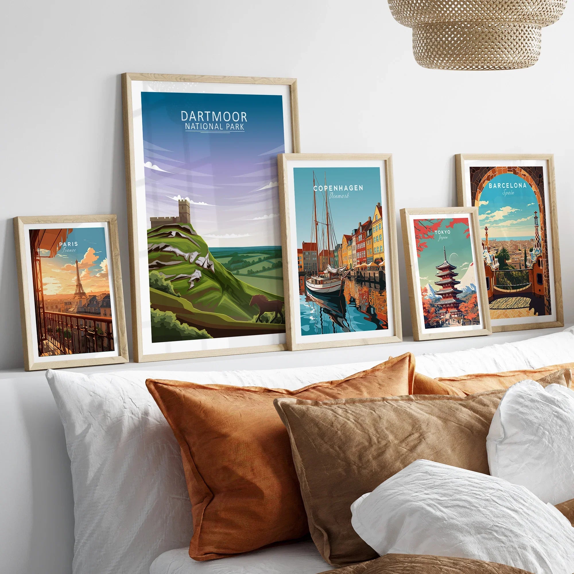 Travel poster wall art set in natural wood frames above bed, featuring city and national park prints.