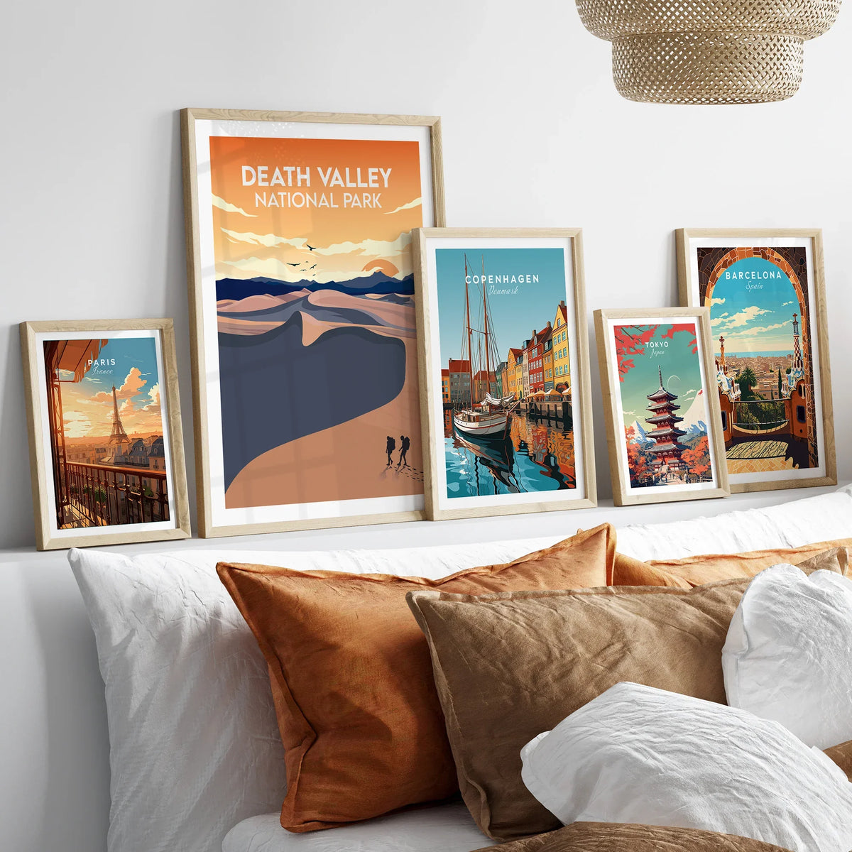 Framed travel art prints of Death Valley, Paris, Copenhagen, Tokyo, and Barcelona above bed.
