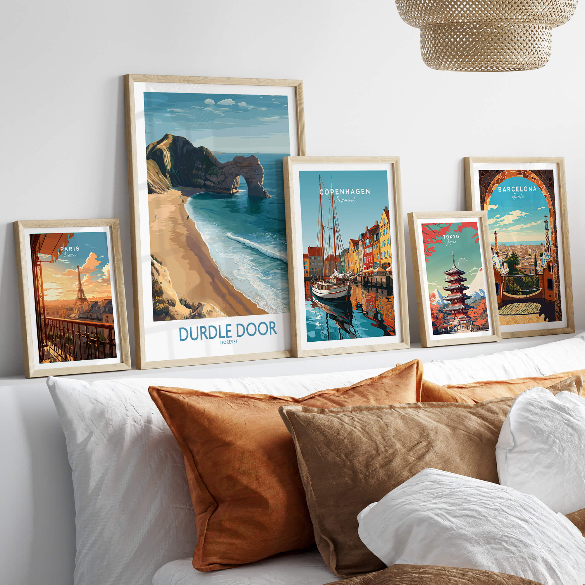 Durdle Door Art Print Dorset Wall Art displayed among other travel-themed art prints on a cozy sofa.